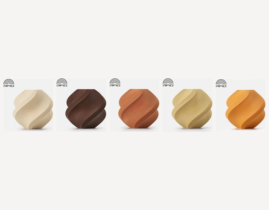 A lineup of Bambu Lab PLA Wood twist vases from light birch to dark walnut