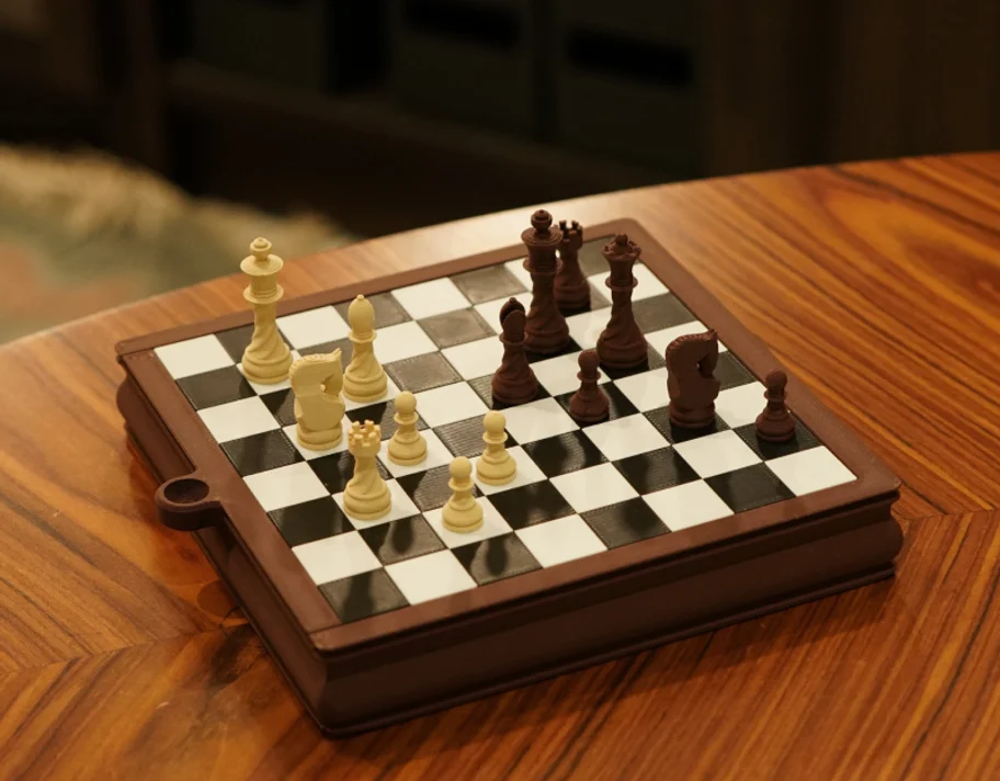 A 3D-printed Bambu Lab PLA Wood travel chess set on a wooden table